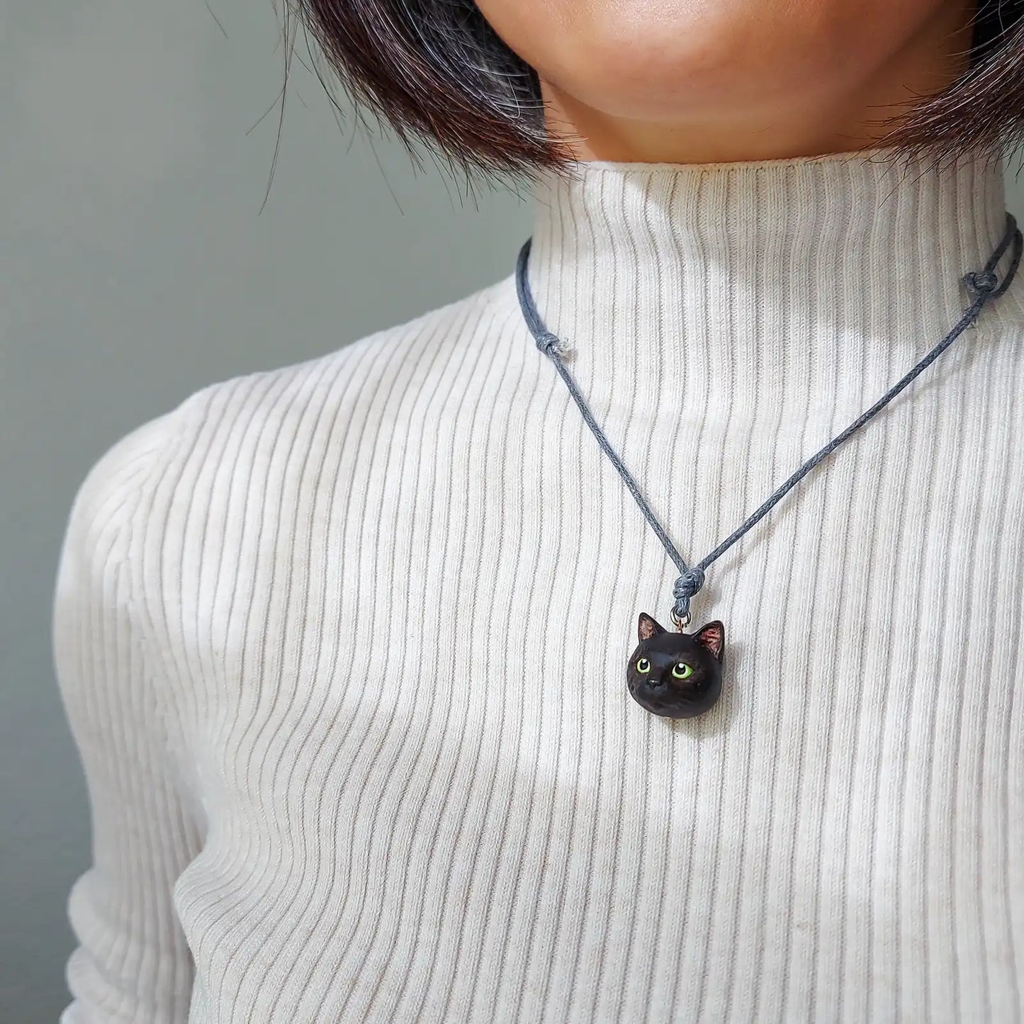 cat domestic shorthair black colour green eyes pendant wearing