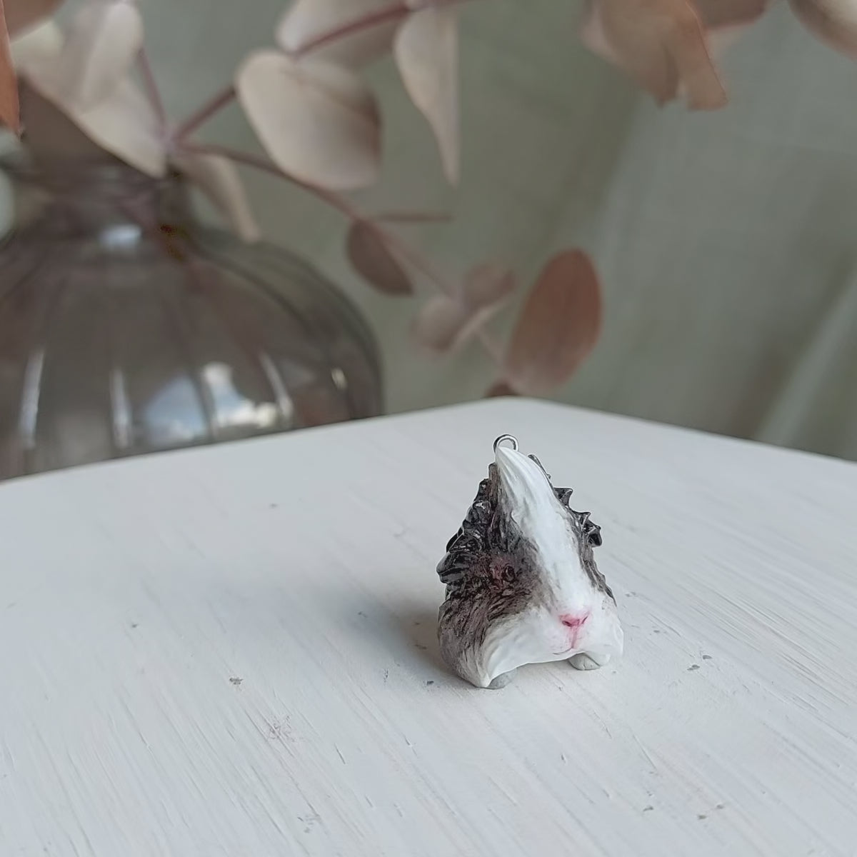Elegant grey & white Abyssinian guinea pig pendant necklace with lifelike details on turn table